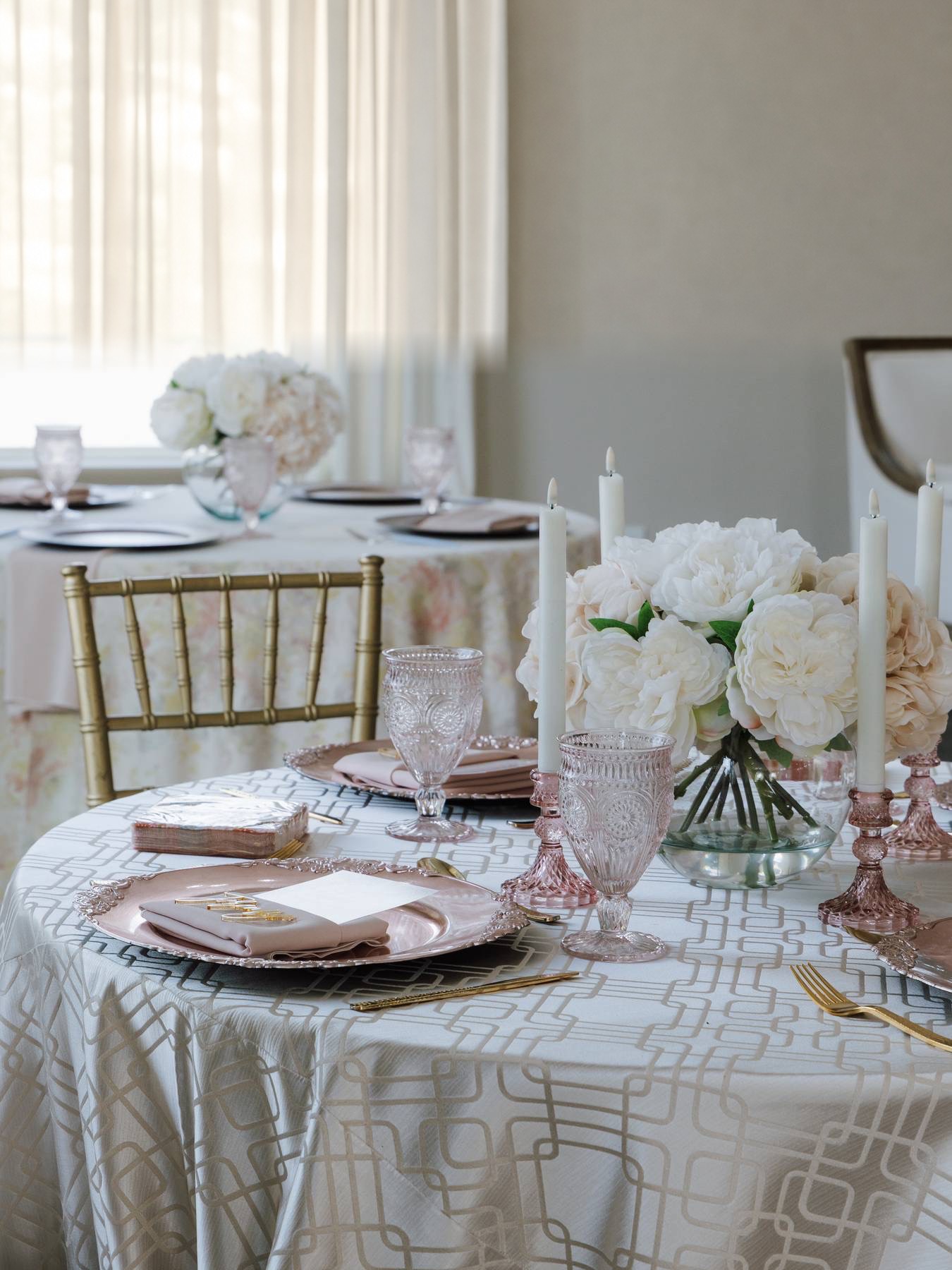 Ivory floral centerpieces and champagne gold chairs in Magnolia Studio’s event room
